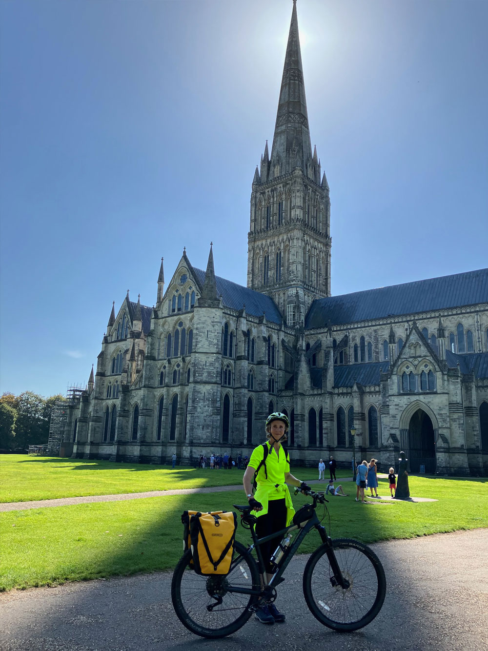 lady with a bike infront of a cathedral 