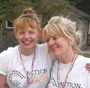 2 ladies with medals on, one arm round others shoulder