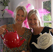Cathy & sister Susy holding large tea pots