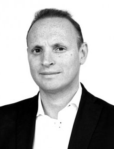 Professor Justin Stebbing Black and white portrait photo of a man in a suit