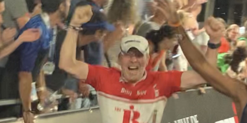Man in cycling gear running and cheering.